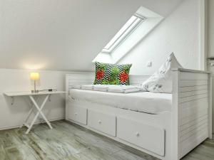 a white bedroom with a bed and a desk at Am Krabbenweg Whg.2 im Haus Am Krabbenweg in Insel Poel