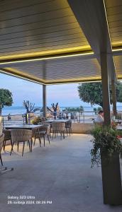 eine Gruppe von Tischen und Stühlen unter einem Pavillon mit Strand in der Unterkunft Adela Apartments Žnjan Split in Split