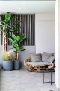 een woonkamer met een rotan bank en planten bij Dom in Lefkada