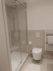 a white bathroom with a shower and a toilet at Luxurious duplex design-flat Kensington in London