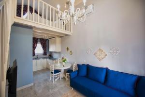 a living room with a blue couch and a table at Nafsika Suites in Nea Moudania