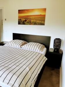 a bedroom with a bed and a picture on the wall at Modernes Apartment am Waldrand in Geisenheim