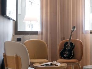 eine Gitarre auf zwei Stühlen in einem Raum in der Unterkunft ibis Paris Rueil Malmaison in Rueil-Malmaison