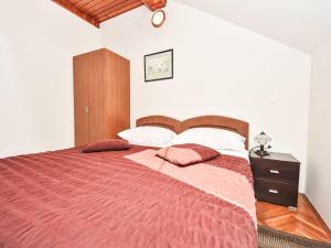 Un dormitorio con una cama grande con un edredón rojo. en Apartment Bastaja Rastoke by Interhome, en Slunj