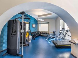 a fitness room with a gym with cardio equipment at Mercure Napoli Centro Angioino in Naples