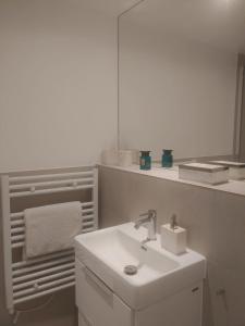 a white bathroom with a sink and a mirror at Luxurious duplex design-flat Kensington in London