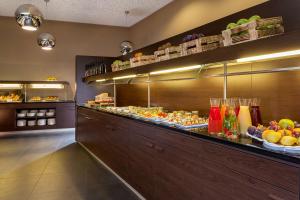a buffet line in a restaurant with fruits and vegetables at NH Collection Dresden Altmarkt in Dresden