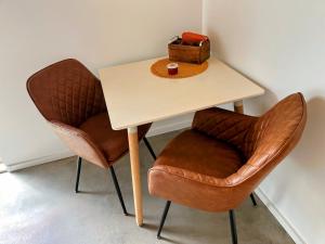 a table with two chairs and a box on it at Modernes Apartment am Waldrand in Geisenheim