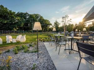 Ibis Hotel Plzeň في بلزن: فناء به طاولات وكراسي في حديقة