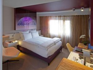 a hotel room with a large bed and a desk at Pullman Eindhoven Cocagne in Eindhoven