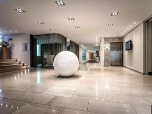 a lobby with a large white sphere in the middle at Pullman Eindhoven Cocagne in Eindhoven