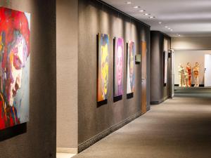 a hallway with paintings on the walls of a museum at Pullman Eindhoven Cocagne in Eindhoven