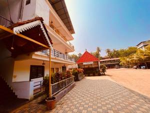 a building with a red roof next to a street at The Nature Walk Beach Resort Goa in Candolim
