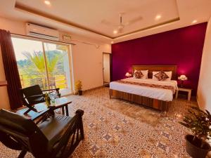 a bedroom with a bed and a purple wall at The Nature Walk Beach Resort Goa in Candolim