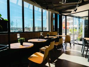a restaurant with tables and chairs and large windows at Ibis Valladolid in Valladolid