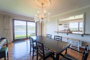 a dining room with a table and chairs and a chandelier at Dingle Bay Nest in Dingle