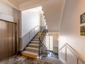 - un escalier dans un immeuble avec rampe d'escalier dans l'établissement ibis Nice Centre Notre Dame, à Nice