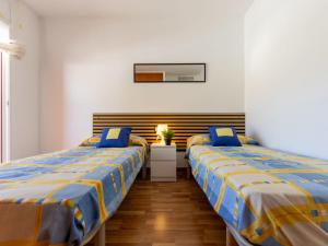 two beds are in a room with white walls at Holiday Home Cal 5inc by Interhome in Creixell