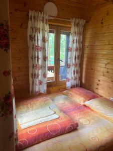 a bedroom with a large bed in a log cabin at Drinski Maldivi 2 in Vrhpolje
