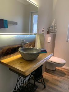 a bathroom with a bowl sink on a wooden counter at Zu Fuß zum Strand - familienfreundlich zwischen Wismar und Boltenhagen Wallbox am Haus! in Beckerwitz