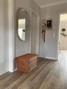a hallway with a wicker basket and a mirror at Zu Fuß zum Strand - familienfreundlich zwischen Wismar und Boltenhagen Wallbox am Haus! in Beckerwitz