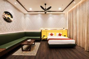 a hotel room with two beds and a green couch at Muhurat Hotel and Resort, in Māndhar
