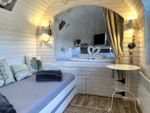 Cette petite chambre comprend un lit et un miroir. dans l'établissement Iglu Camp Templin, à Templin