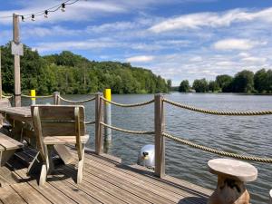 a wooden dock with a bench and a rope fence at Iglu Camp Templin in Templin