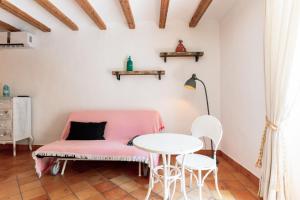 a room with a pink couch and a table at Origens I - Precióso apartamento in Perelló