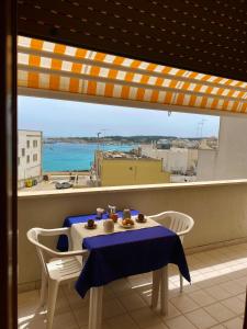 una mesa en un balcón con vistas al océano en Casa Zia Gianna en Otranto
