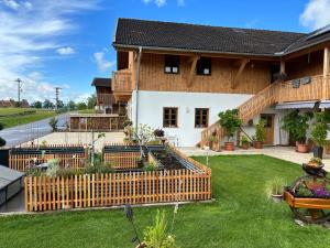 a house with a wooden fence in the yard at Ferienwohnung zwischen Burghausen und Salzburg in Tittmoning