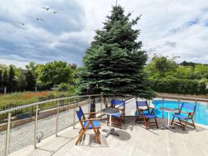 a deck with chairs and a table and a tree at Twins Palace ApartHotel in St. St. Constantine and Helena