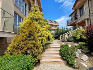 a stairway leading up to a building with a tree at Twins Palace ApartHotel in Saints Constantine and Helena