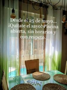 薩拉曼卡的住宿－Sol de Poniente，一张带椅子的玻璃桌,上面有标志