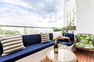 - un canapé bleu sur un balcon avec une table dans l'établissement Seabreeze Retreat with terrace - St Julians, à San Ġiljan