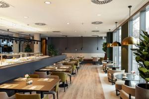 a restaurant with tables and chairs and a bar at NH Köln Altstadt in Cologne