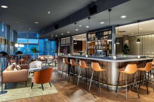 a bar in a hotel lobby with chairs and tables at NH Köln Altstadt in Cologne