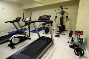 ein Fitnessstudio mit mehreren Ergometern und einem Laufband in der Unterkunft Hotel Curi Executive in Pelotas