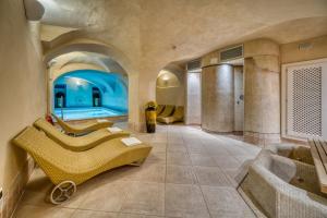 ein großes Badezimmer mit Swimmingpool und Badewanne in der Unterkunft Hotel Eden in Levico Terme