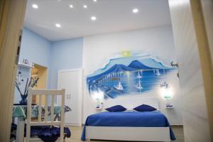 una camera da letto con un letto e una parete blu di Solemare Musica & Poesia a Napoli