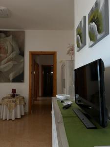 sala de estar con mesa y TV en Casa Zia Gianna en Otranto