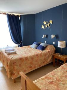1 Schlafzimmer mit 2 Betten und blauen Wänden in der Unterkunft LES TERRASSES DU LAC in Chaumard