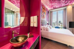 różowa łazienka z łóżkiem i umywalką w obiekcie nhow Frankfurt w Frankfurcie nad Menem
