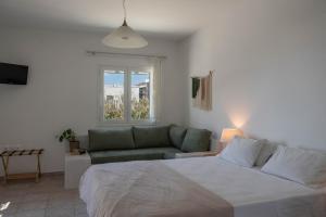 a bedroom with a large bed and a couch at Almira Studios in Kionia