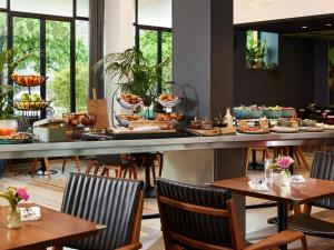 a restaurant with a buffet of food on a counter at Molitor Hôtel & Spa Paris - MGallery Collection in Paris