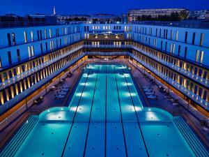 un gran edificio con piscina por la noche en Molitor Hôtel & Spa Paris - MGallery Collection en París