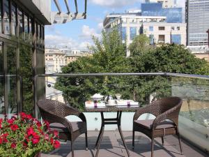 patio con mesa y sillas en el balcón en Mercure Arbat Moscow, en Moscú