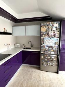 a kitchen with purple cabinets and a refrigerator with magnets at Duplex Moaña Centro in Moaña