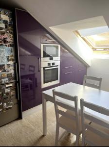 a kitchen with a table and a stove and a microwave at Duplex Moaña Centro in Moaña +1 photo