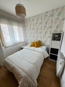 a bedroom with a large bed with a yellow pillow at Duplex Moaña Centro in Moaña